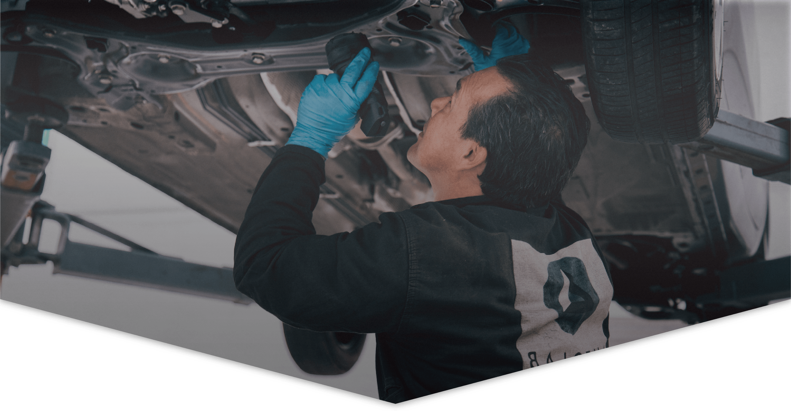 Mecánico de Autolab inspecciona un carro desde abajo hacer un mecánico básica