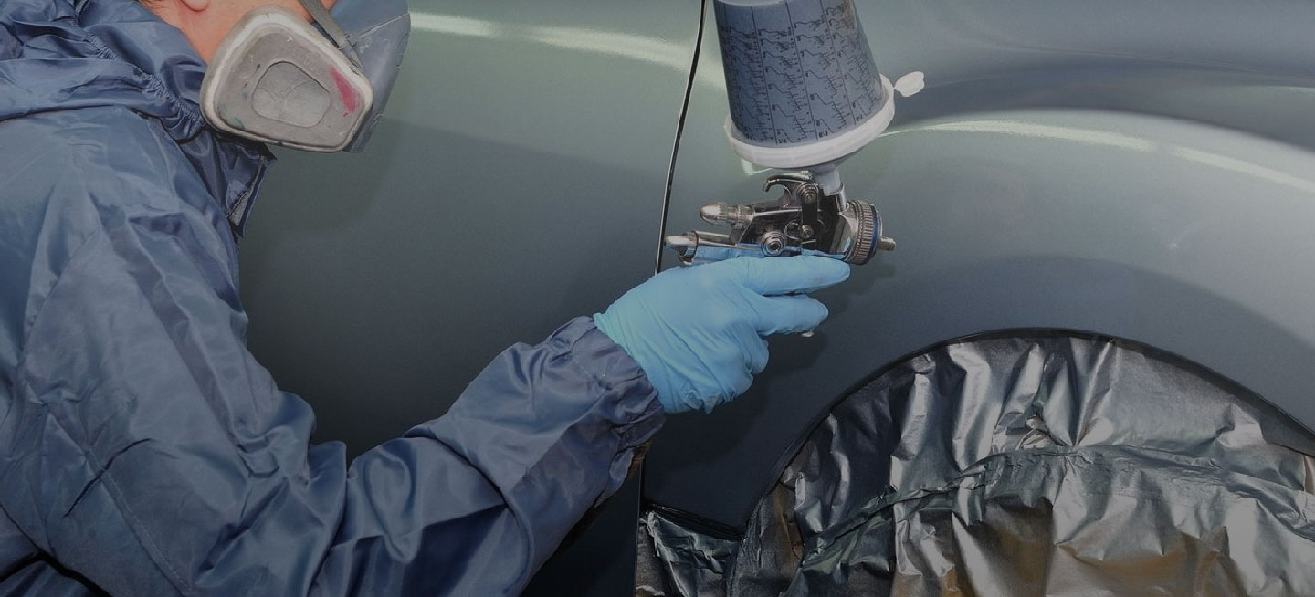Un mecánico pintando un carro